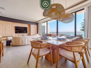 a dining room with a table with chairs and a couch at Luxury Oceanfront 3 BR Condo with Balcony in Cruz de Huanacaxtle