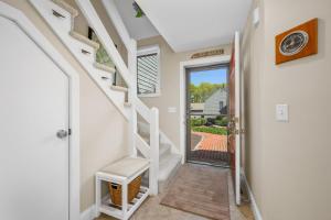 a hallway with stairs leading to a door with a view at Sea Spark - Cape Escape with Pool Access in Mashpee +40 photos