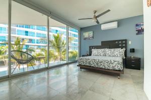 a bedroom with a bed and large windows at Beachfront Duplex with Multiple Pools - Beachclub in Nuevo Vallarta +36 photos