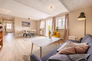 a living room with a couch and a table at Kalvestalden - A Cozy Holiday Home in Hjørring