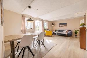 a dining room and living room with a table and chairs at Kalvestalden - A Cozy Holiday Home in Hjørring