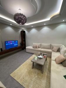 a living room with a couch and a tv at غرفه وصاله in Tabuk