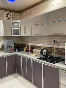 a kitchen with gray cabinets and a stove top oven at غرفه وصاله in Tabuk