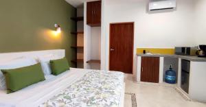 ein Schlafzimmer mit einem Bett mit grün-weißer Bettwäsche in der Unterkunft Valentina Holbox by Las Flores Vacation Rentals in Holbox