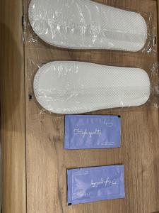 two plastic shoes sitting on a wooden table with two cards at غرفه وصاله in Tabuk