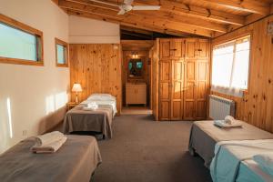 ein Zimmer mit drei Betten und einer Küche darin in der Unterkunft Casa 45 in San Martín de los Andes