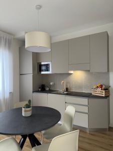 a kitchen with white cabinets and a table and chairs at Appartamento alla Lupa in Vetriola