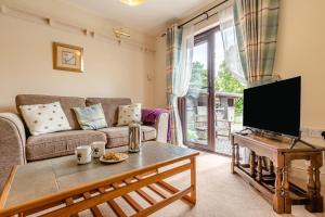a living room with a couch and a tv at 1 Bed in Hope Valley oc-pk849 in Bradwell