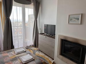 a bedroom with a fireplace and a tv and a bed at Mirabell Studio Bansko - Amazing view & fireplace in Bansko