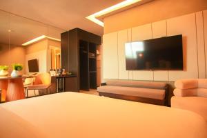 a living room with a couch and a flat screen tv at Uchôa Teresina Hotel in Teresina