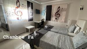a bedroom with a large bed and a desk at Chambres d'hôtes - Écohâme - Guitar Palace in Ouazzane +24 photos