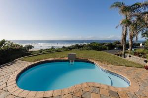 a swimming pool with the ocean in the background at La Vue in Port Shepstone