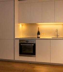 a kitchen with white cabinets and a sink and a oven at Lux Line Apartment in Zurich