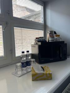 a kitchen counter with bottles of water and a microwave at Cottage 33 in Kirkby Stephen