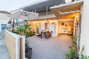 a patio with a table and an umbrella at Vasiliko House in Kalavárda +17 photos