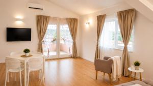 a living room with a table and chairs and a television at Villa Rosa dei Venti in Kaštel