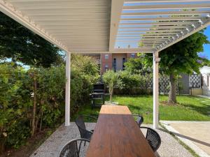 a wooden table and chairs under a pergola at Scavi & Sogni Romani in Ostia Antica