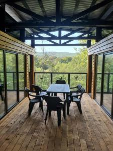 a patio with a table and chairs on a deck at Greengold in Săcădat