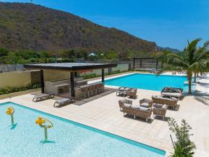 a swimming pool with chairs and a table and a swimming pool at Vela Mare Suite in Santa Marta