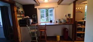 a kitchen with a counter with stools and a window at Tiny house im Wingster Forst in Wingst