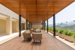 a patio with chairs and a table on a balcony at Vela Mare Suite in Santa Marta