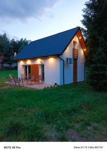 a small house with a table and chairs in a field at Leszczynka in Szarocin