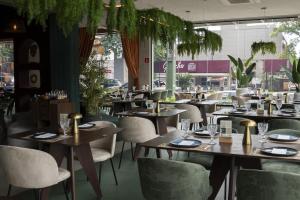 a restaurant with wooden tables and white chairs at Tarobá Hotel in Foz do Iguaçu
