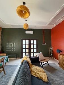 a living room with green and red walls and a couch at Tamu Beradu Seaview Private Pool Villa in Dungun