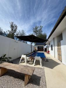 a patio with a bench and an umbrella and a pool at Tamu Beradu Seaview Private Pool Villa in Dungun