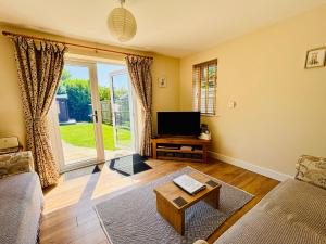 a living room with a couch and a tv at The Old Gate House Annexe in Alford