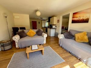 a living room with two couches and a coffee table at The Old Gate House Annexe in Alford +12 photos