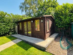 a small wooden shed sitting in the grass at The Old Gate House Annexe in Alford