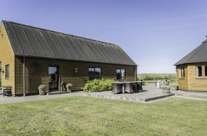 a wooden house with a picnic table in front of it at Fantastic Holiday Property Kragelund For Up To 24 Guests! in Åbybro