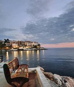 a bench sitting on the edge of a body of water at Lemon tree House in Skala Marion