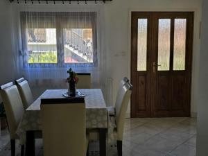 a dining room with a table and chairs and a door at Apartman Humac in Otočac