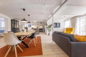a dining room and living room with a table and chairs at Kostalden A Cozy Setting For Family Time in Hjørring