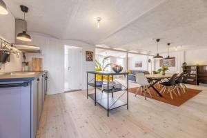 a kitchen and living room with a table and chairs at Kostalden A Cozy Setting For Family Time in Hjørring +28 photos