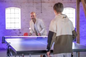a man standing in front of a ping pong table at Kostalden A Cozy Setting For Family Time in Hjørring