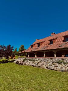 a building with a stone wall next to a yard at Karczma Bełty in Glinno