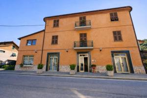 a large orange building with potted plants in front of it at Hotel Degli Angeli in Pontinvrea