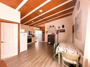 a room with a table and a kitchen with a refrigerator at Casa Olivia Sant Lluis in Sant Lluis
