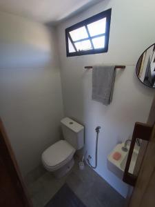 a bathroom with a toilet and a sink and a window at Chalé Punaras in Araruna