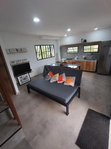 a living room with a couch and a kitchen at Chalé Punaras in Araruna