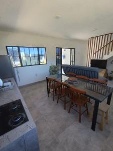 a living room with a table and chairs and a stove at Chalé Punaras in Araruna +24 photos