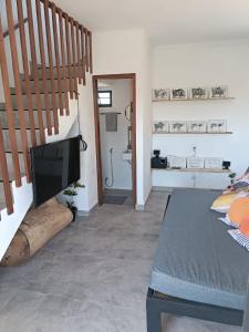a living room with a television and a staircase at Chalé Punaras in Araruna