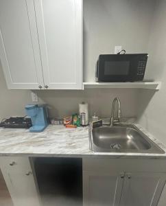 a kitchen counter with a sink and a microwave at The Comfort Cove in Cleveland