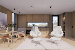 a living room with two white chairs and a table at Lyngen Experience Lodge in Nord-Lenangen