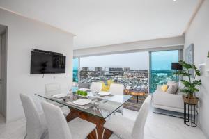 a dining room with a glass table and white chairs at Nautico nautico 8a in Puerto Vallarta