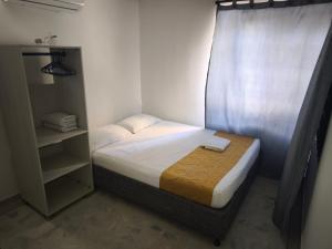 a small bedroom with a bed and a curtain at Gaia Rodadero in Santa Marta