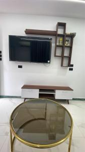 a glass coffee table with a tv on a wall at Luxury king studio in 6th Of October